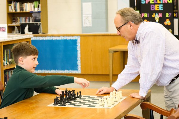 A Doane Stuart student plays chess with a teacher