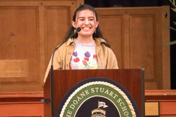 A Doane Stuart student at a podium in front of classmates